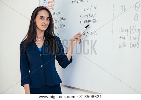 Teacher Near Whiteboard Explains The Rules. Learn Foreign Language.