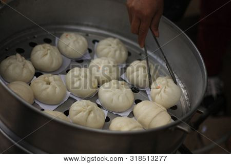 Steamed Buns Being Cooked And Served From A Steamer Tray