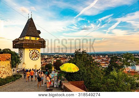 Graz, Austria - 17.08.2019 : View At Famous Clock Tower Uhrturm At Schlossberg Hill. Tourists Walkin