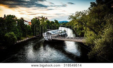 Graz, Austria - 17.08.2019: View At Mur River, Murinsel On Bridge, People Enjoy Beautiful Summer. Tr