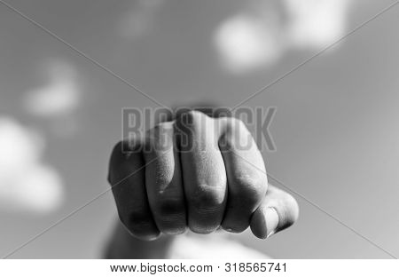 Aggressive Caucasian Teenage Boy Showing Hes Fist To The Camera Outdoors Monochrome Image, Shallow D