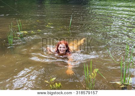 Girl Swims In The River, Brunette Swims In The Pond, The River Angrapa, Kaliningrad Region, Russia, 