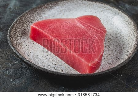 Raw Fresh Tuna Stek On Gray Plate. Black Background