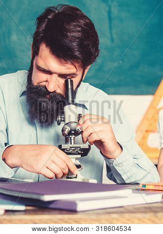 Looking Through The Microscope. Bearded Man Teacher. Back To School. Experimenting With Chemicals Or