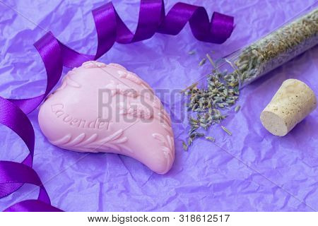 Handmade Heart Shaped Lavender Soap On A Violet Crumpled Paper Background With A Glass Flask With Dr
