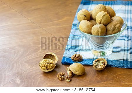 Whole Walnuts And Walnut Kernel Halves Without Shell On A Dark Wooden Table And Checkered Towel, Clo