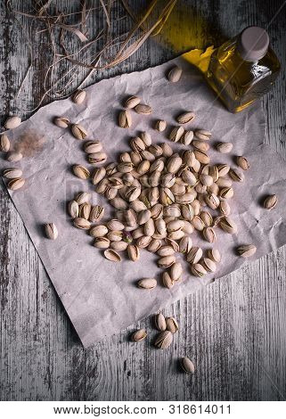 Pistachios On Wooden Table In The Foreground With Darkened Background