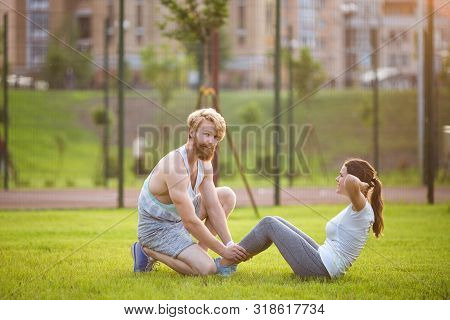Sit Ups Fitness Couple Exercising Sit Up Outside In Grass. Fit People Working Out Cross Training. Wo