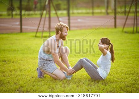 Sit Ups Fitness Couple Exercising Sit Up Outside In Grass. Fit People Working Out Cross Training. Wo