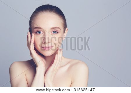 Portrait Of Beautiful Woman With Natural Make Up Touching Her Face.