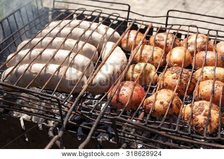 The Process Of Cooking Food In The Fresh Air In Nature, Grilled Georgian  Pork Sausages And Potatoes