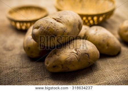 Close Up Shot Of Potato Or Aloo Or Alu On Jute Bag Surface Along With Two Vegetable And Fruit Hamper