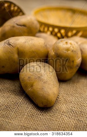 Close Up Shot Of Potato Or Aloo Or Alu On Jute Bag Surface Along With Two Vegetable And Fruit Hamper