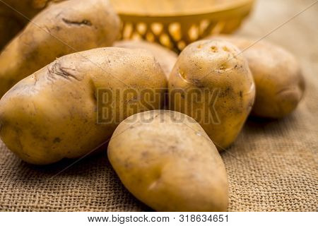 Close Up Shot Of Potato Or Aloo Or Alu On Jute Bag Surface Along With Two Vegetable And Fruit Hamper