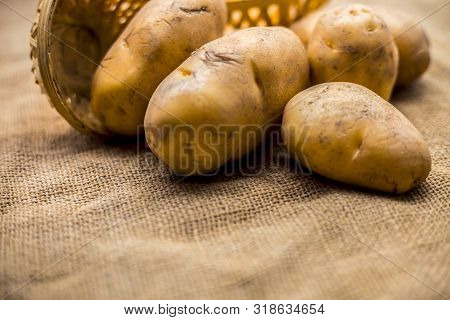 Close Up Shot Of Potato Or Aloo Or Alu On Jute Bag Surface Along With Two Vegetable And Fruit Hamper
