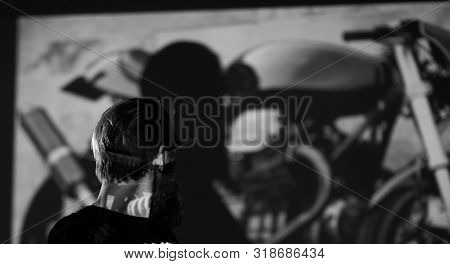 Male Biker Standing In The Background Of The Photo Of His Motorc