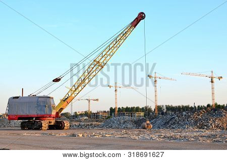 Large Crawler Crane Or Dragline Excavator With A Heavy Metal Wrecking Ball On A Steel Cable. Wreckin