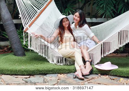 Young And Cute Asian Women Lying In A Hammock During Holiday