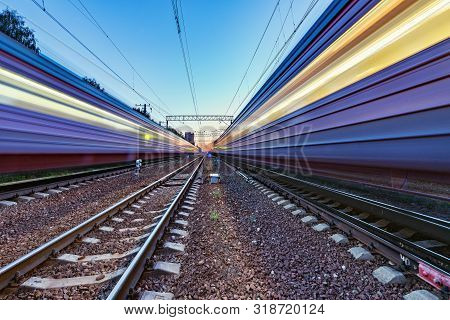 Two Trains Move Fast To The Different Directions At Sunset Time.