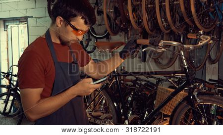Theme Small Business Bike Repair. Young Caucasian Brunette Man Wearing Safety Goggles, Gloves And Fa