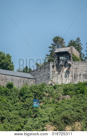 Dinant, Belgium - June 26, 2019: Blue Cable Car Against Green Foliage Bringing Visitors Up Along Gra