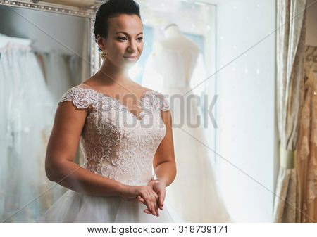 Beautifu bride choosing wedding dress in a wedding salon