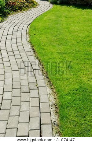 Garten Stein Weg mit Gras zwischen den Steinen wachsen