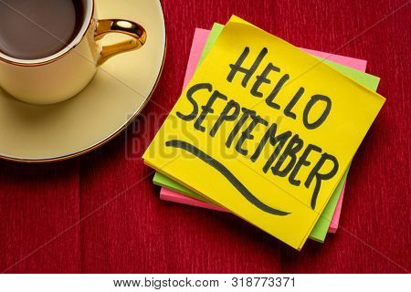 Hello September - handwriting on a sticky note with a cup of coffee