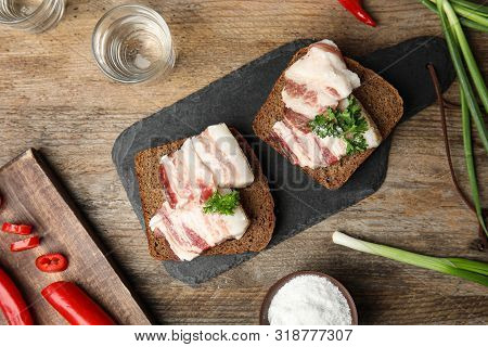 Board With Pork Fatback Sandwiches, Shots Of Vodka, Onion And Pepper On Wooden Background, Flat Lay
