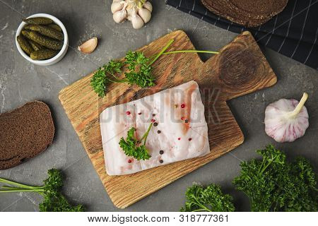 Board With Pork Fatback, Garlic, Parsley, Bread And Bowl Of Pickles On Grey Stone Background, Flat L
