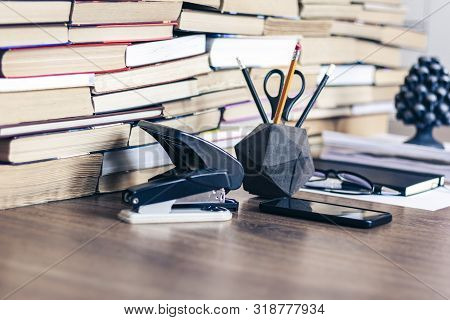 Stack Of Old Book On Wooden Table, Notebook, Smartphone, Stationery And Paperweight. Education Write