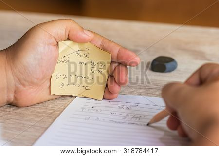 Student Using Formula Math Sheet To Cheat On Test. Hand Of University Student Holding Pencil Doing M