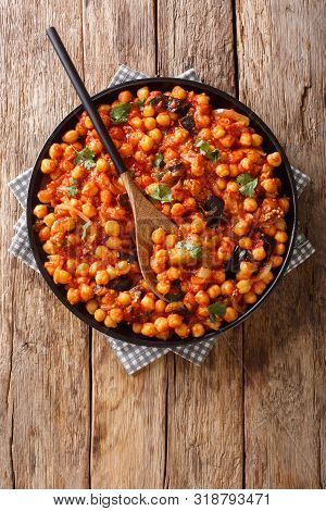 Tasty Fried Chickpeas With Eggplant In Tomato Sauce Close-up On A Plate On The Table. Vertical Top V