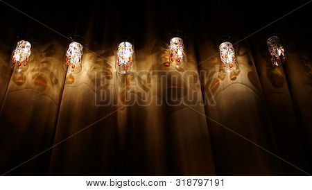 Set Beautiful Lamp With Red Glass Drops On Dark Curtain Background Of Similiar Shapes.