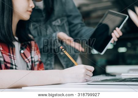Young Studebt Sitting In Library College Studying And Sharing Knowledge With Laptop Together, Educat