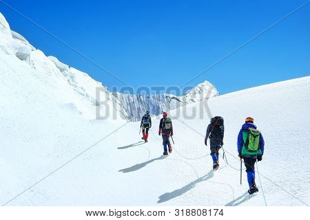 Climber Reaches The Summit Of Mountain Peak Enjoying The Landscape View.