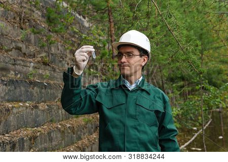 Industrial Ecologist Or Hydrologist Takes A Sample Of Water From Old Quarry