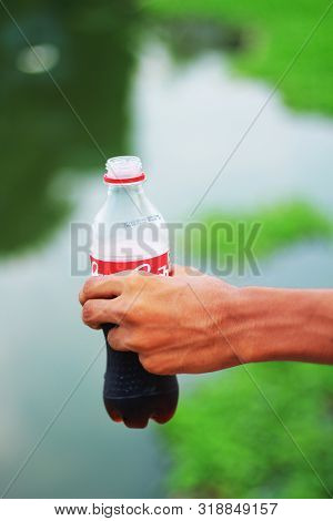 A Cocacola Bottle Holed With A Single Hand