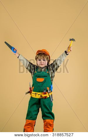 Cute Little Builder In Hard Hat With Hammer, Saw. Little Boy In Builders Uniform With Tools. Little 