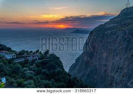 Sun Setting Over The Trees And Buildings While Sun Sets Over Mediterranean Sea