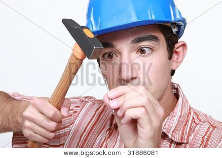Builder rammer sømmet med hammer