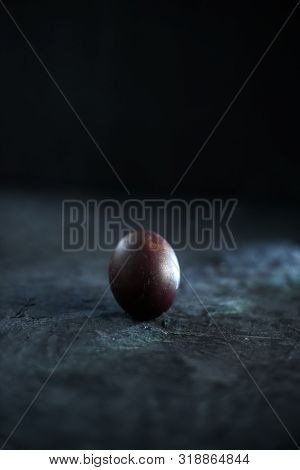 Dark Purple Eggs On A Rough Cement Background.