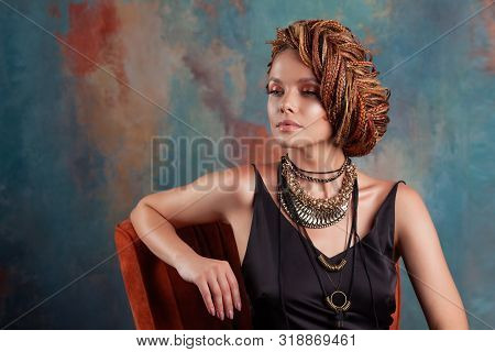 Southern Flavor. Stylish Beautiful Young Woman With Afro Braids Tucked Into A High Hair, Sitting In 
