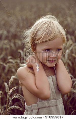 Girl In Long Dress Stands In A Field With Spikelets