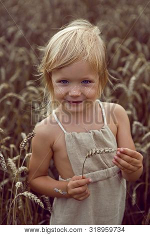 Girl In Long Dress Stands In A Field With Spikelets