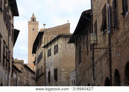 Ancient Tuscan Walled City Houses With Towers And Stone Walls And Paved Cobbled Streets In Italy