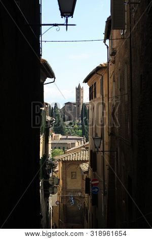 Ancient Tuscan Walled City Houses With Towers And Stone Walls And Paved Cobbled Streets In Italy