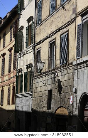 Ancient Tuscan Walled City Houses With Towers And Stone Walls And Paved Cobbled Streets In Italy