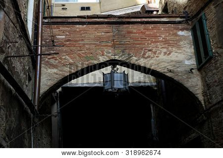 Ancient Tuscan Walled City Houses With Towers And Stone Walls And Paved Cobbled Streets In Italy