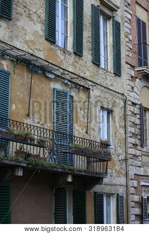 Ancient Tuscan Walled City Houses With Towers And Stone Walls And Paved Cobbled Streets In Italy